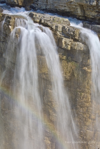 View of a portion the main falls from the upper viewing platform, with a rainbow in the mist.